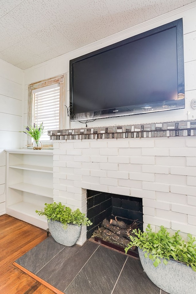 room details featuring a fireplace, wood finished floors, and wood walls