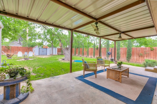 view of patio / terrace featuring an outdoor living space, a fenced backyard, ceiling fan, an outbuilding, and a storage shed