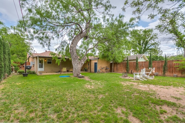 view of yard featuring a patio, a fenced backyard, and an outdoor fire pit