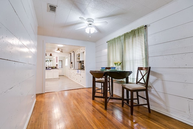 dining area featuring visible vents, ceiling fan, and light wood finished floors