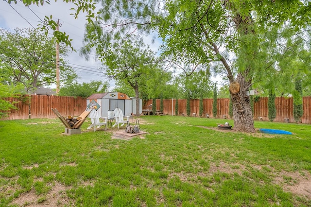 view of yard with a storage shed, an outdoor structure, and a fenced backyard