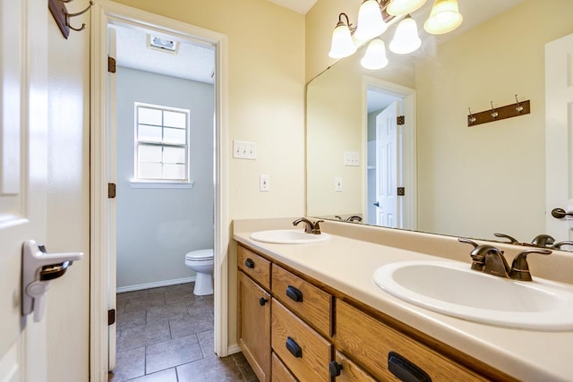 bathroom featuring vanity, toilet, and a chandelier