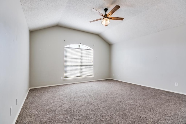 unfurnished room featuring carpet floors, a textured ceiling, vaulted ceiling, and ceiling fan