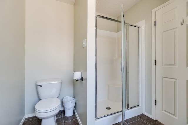 bathroom featuring toilet, tile patterned floors, a textured ceiling, and a shower with shower door