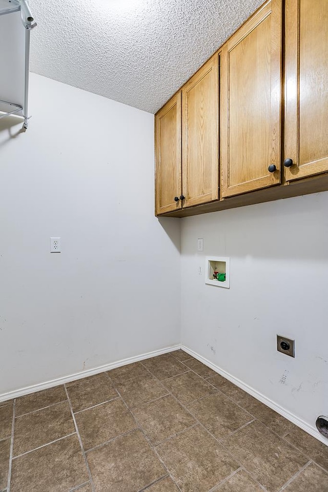 laundry room with electric dryer hookup, washer hookup, cabinets, and a textured ceiling