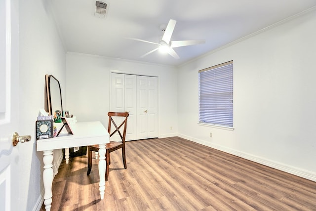home office featuring light wood-style floors, ceiling fan, baseboards, and ornamental molding