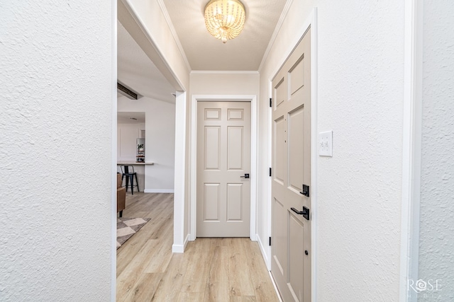 1702 Parkview Dr, San Angelo, TX 76904 - corridor with light wood-type flooring, a chandelier, ornamental molding, a textured wall, and baseboards