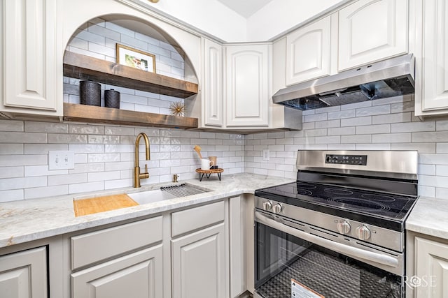 1702 Parkview Dr, San Angelo, TX 76904 - kitchen featuring stainless steel range with electric cooktop, under cabinet range hood, open shelves, tasteful backsplash, and white cabinets