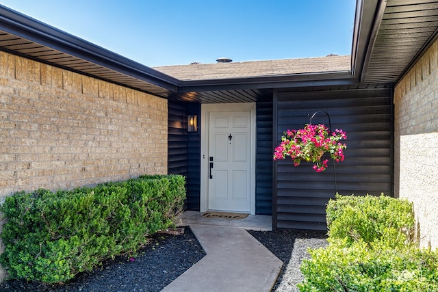 1702 Parkview Dr, San Angelo, TX 76904 - view of exterior entry featuring a shingled roof and brick siding
