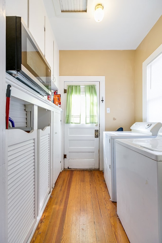 laundry area featuring washer and clothes dryer and light hardwood / wood-style floors