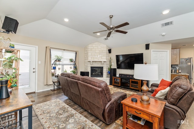 living room featuring lofted ceiling, dark wood-type flooring, a fireplace, and ceiling fan