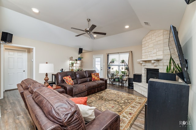 living room with a fireplace, dark hardwood / wood-style floors, ceiling fan, and vaulted ceiling