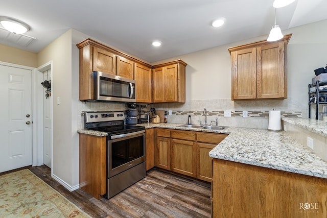 kitchen featuring sink, backsplash, dark hardwood / wood-style flooring, stainless steel appliances, and light stone countertops