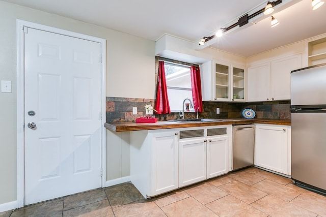 2526 Harvard Ave, San Angelo, TX 76904 - kitchen with stainless steel appliances, a sink, dark countertops, backsplash, and glass insert cabinets