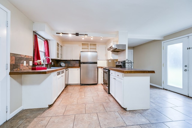 2526 Harvard Ave, San Angelo, TX 76904 - kitchen with stainless steel appliances, dark countertops, a peninsula, a sink, and tasteful backsplash