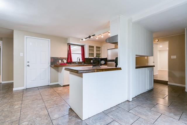 2526 Harvard Ave, San Angelo, TX 76904 - kitchen with freestanding refrigerator, dark countertops, backsplash, white cabinetry, and a sink