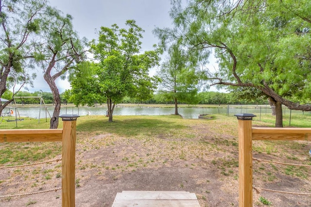 view of yard featuring fence and a water view