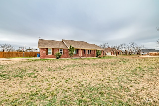 single story home with a front yard, fence, and brick siding