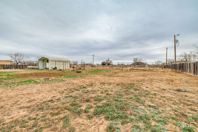 view of yard featuring a detached carport and fence