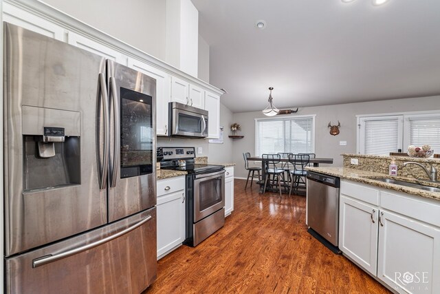 kitchen featuring a sink, light stone counters, appliances with stainless steel finishes, white cabinetry, and dark wood-style flooring