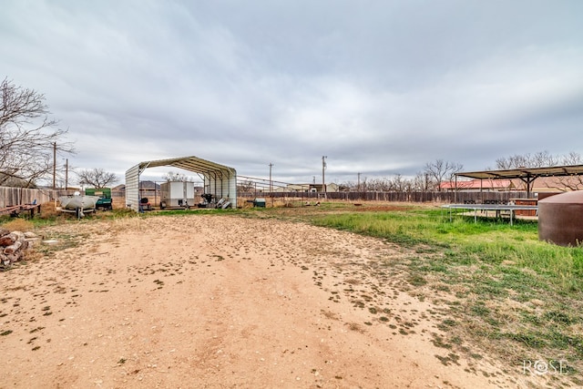 view of yard featuring a detached carport and fence