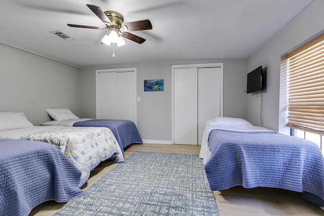 2458 Fishermans Rd, San Angelo, TX 76904 - bedroom with two closets, a ceiling fan, wood finished floors, and baseboards