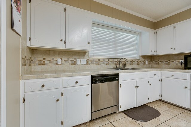 kitchen with crown molding, stainless steel dishwasher, white cabinets, a sink, and decorative backsplash