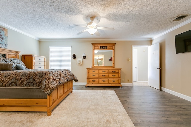 bedroom featuring a textured ceiling, wood finished floors, ornamental molding, and visible vents