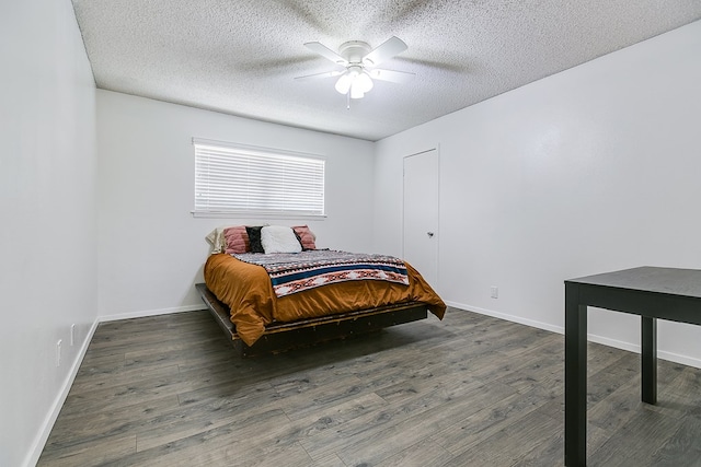 bedroom featuring baseboards, a ceiling fan, wood finished floors, and a textured ceiling