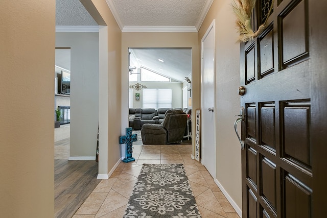 corridor featuring baseboards, a textured ceiling, ornamental molding, and light tile patterned flooring