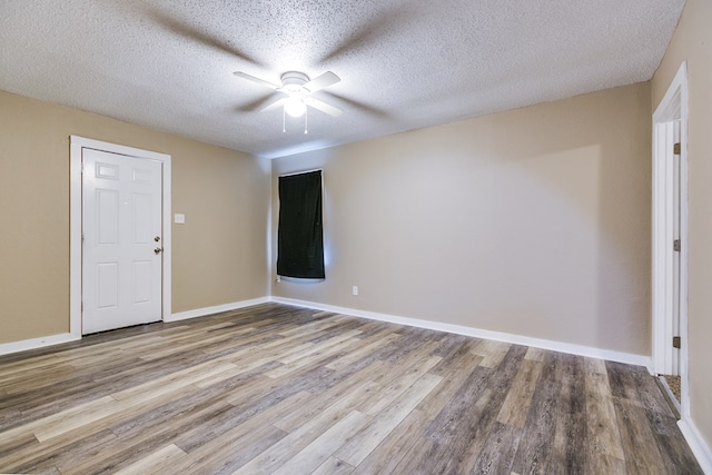 empty room with ceiling fan, a textured ceiling, and light wood-type flooring