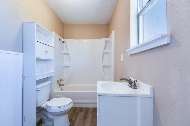 full bathroom featuring hardwood / wood-style floors, vanity, a textured ceiling, bathtub / shower combination, and toilet