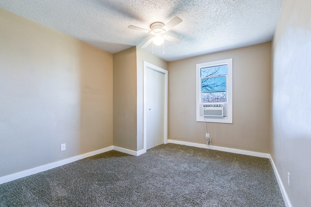 unfurnished bedroom with dark colored carpet, a textured ceiling, a closet, cooling unit, and ceiling fan