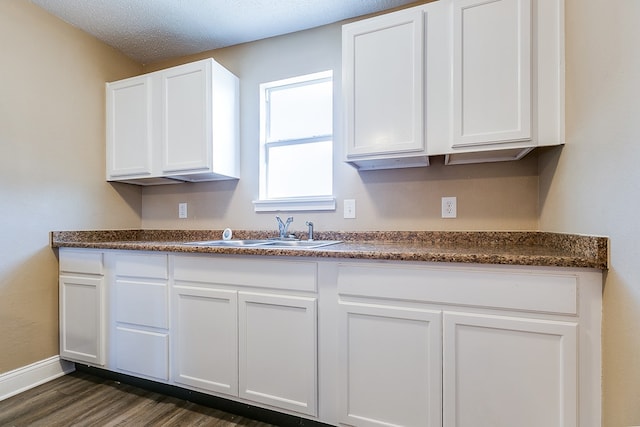 kitchen featuring white cabinetry, sink, dark hardwood / wood-style flooring, and a textured ceiling