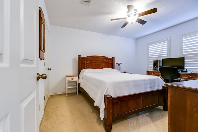 carpeted bedroom featuring a textured ceiling and ceiling fan