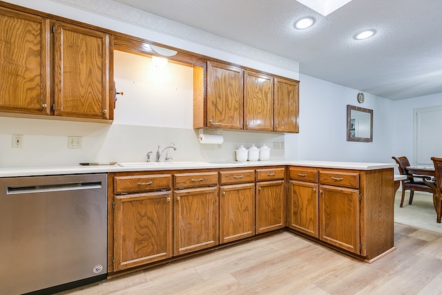 kitchen featuring stainless steel dishwasher, kitchen peninsula, a textured ceiling, and light wood-type flooring