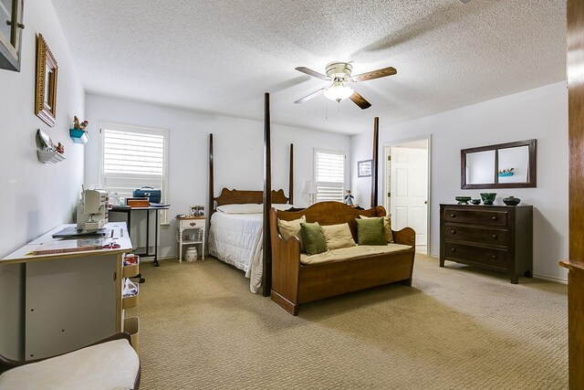 bedroom featuring light carpet, a textured ceiling, and ceiling fan