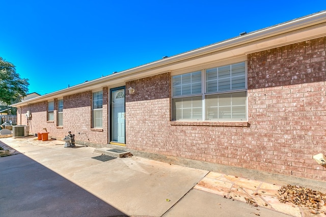 rear view of property featuring central AC unit and a patio area