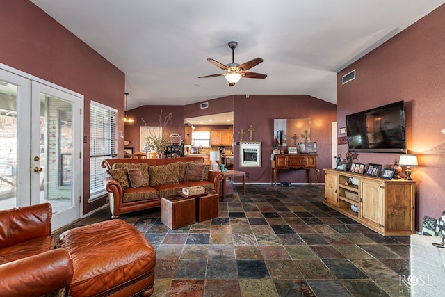 living room with lofted ceiling, french doors, stone finish floor, and visible vents