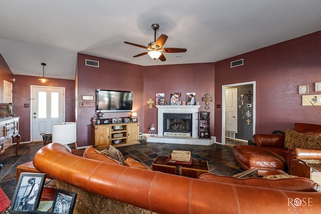 living room with baseboards, a fireplace, visible vents, and a ceiling fan