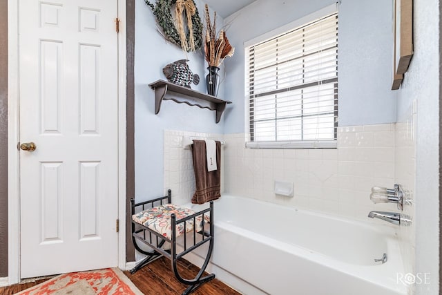 bathroom with a washtub and wood finished floors