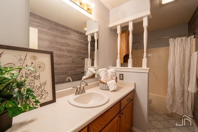 full bathroom with vanity, toilet, a textured ceiling, and shower / bath combo with shower curtain