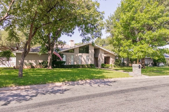 5213 Green Valley Trl, San Angelo, TX 76904 - mid-century home with a chimney, a front lawn, and stucco siding