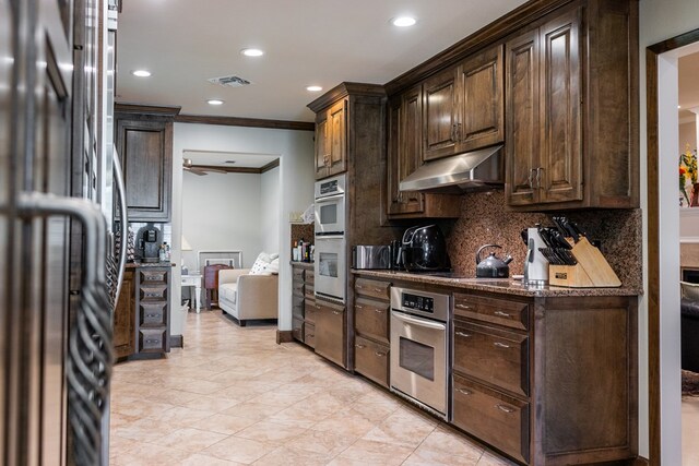 5213 Green Valley Trl, San Angelo, TX 76904 - kitchen featuring stainless steel fridge, under cabinet range hood, crown molding, dark brown cabinets, and decorative backsplash