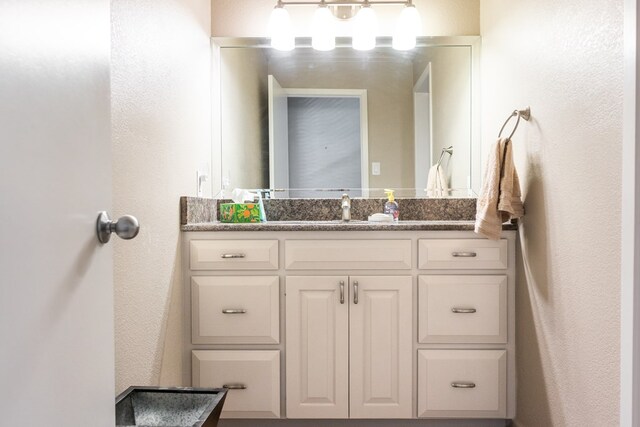 5213 Green Valley Trl, San Angelo, TX 76904 - bathroom with vanity and a textured wall