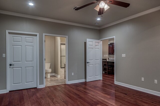 unfurnished bedroom featuring ceiling fan, ensuite bathroom, wood-type flooring, and ornamental molding