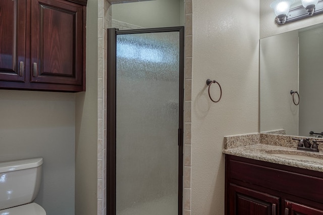 bathroom featuring vanity, toilet, and an enclosed shower