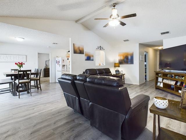 living room with ceiling fan, hardwood / wood-style floors, a textured ceiling, and vaulted ceiling with beams