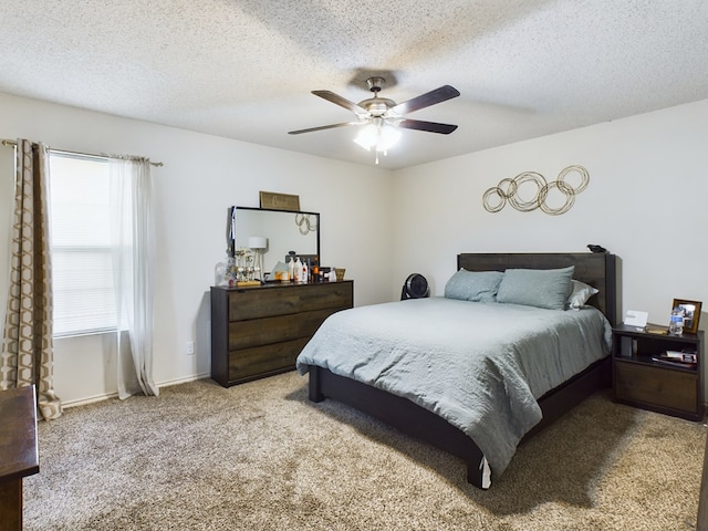 carpeted bedroom featuring ceiling fan and a textured ceiling