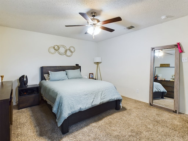 bedroom featuring ceiling fan, carpet floors, and a textured ceiling